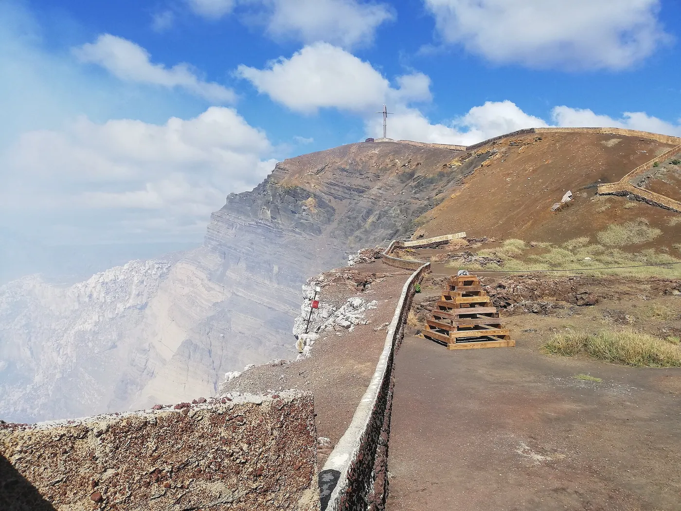 Steam rising from a deep volcanic crater with steep walls