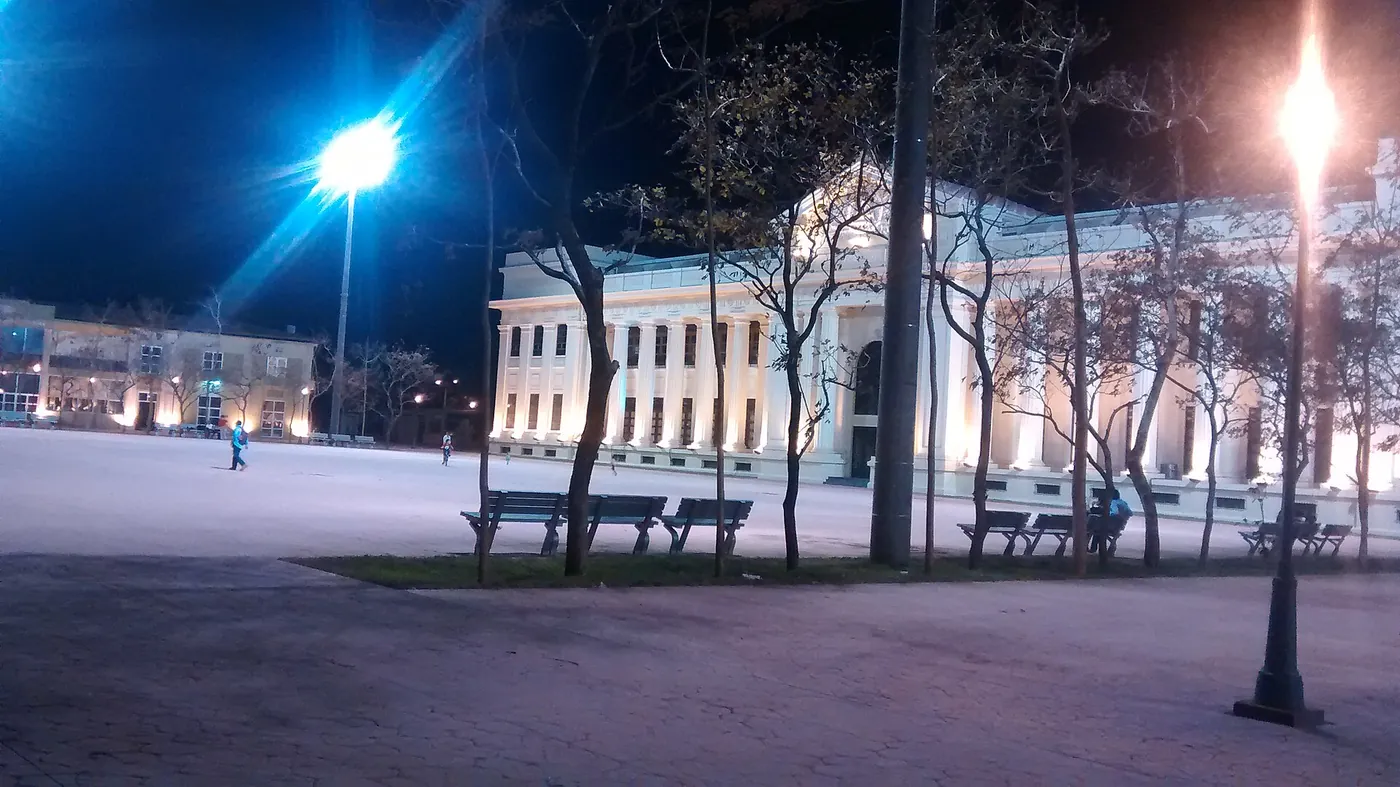 A neoclassical palace building with columns facing a plaza