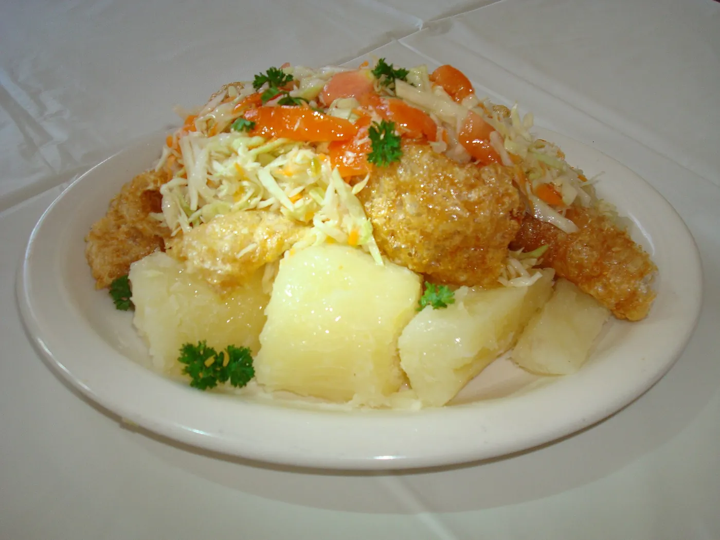 A serving of vigorón with yuca, pork rind and cabbage salad on a banana leaf